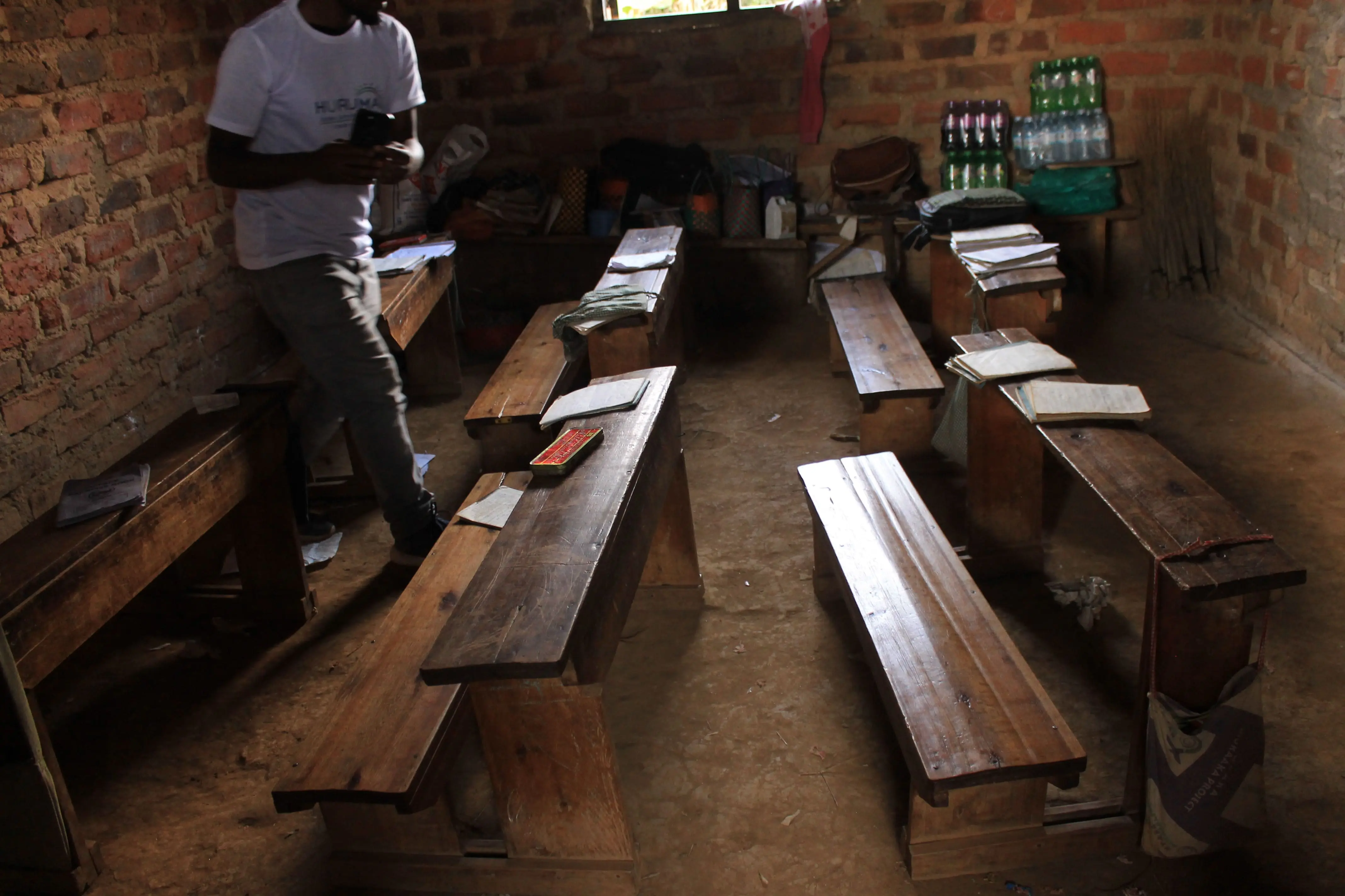 Empty wooden benches in a rural classroom