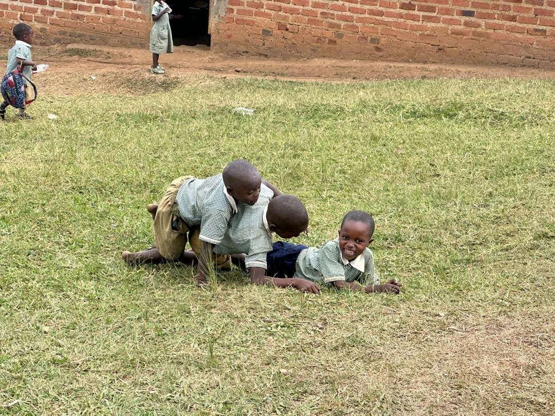 Pupils in school uniform playing on the grass outside their classroom
